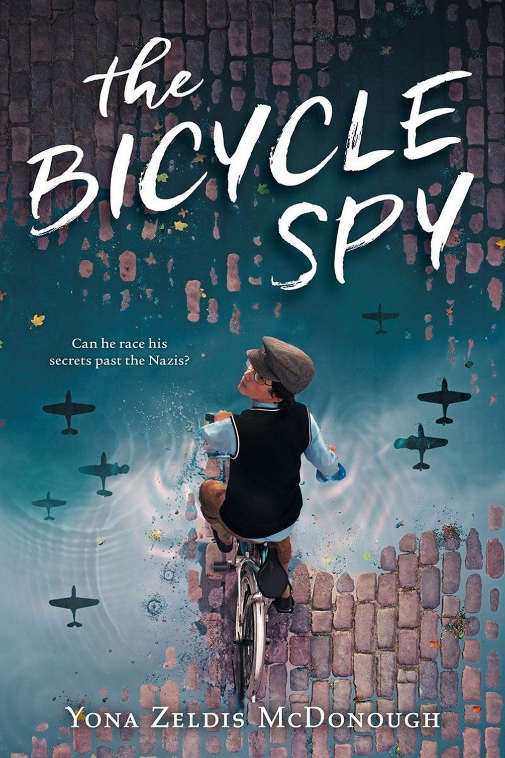 Cover of The Bicycle Spy, with a boy on a bicycle riding on a wet cobblestone street. Warplanes are reflected in the puddles.